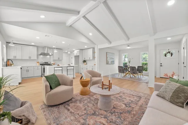 a living room with furniture and view of kitchen
