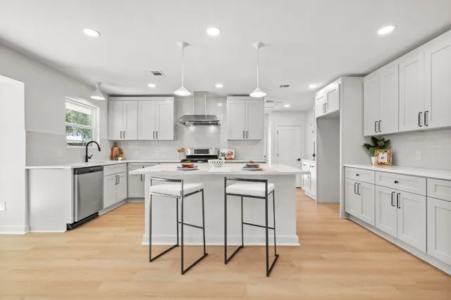 a kitchen with white cabinets stainless steel appliances and a center island