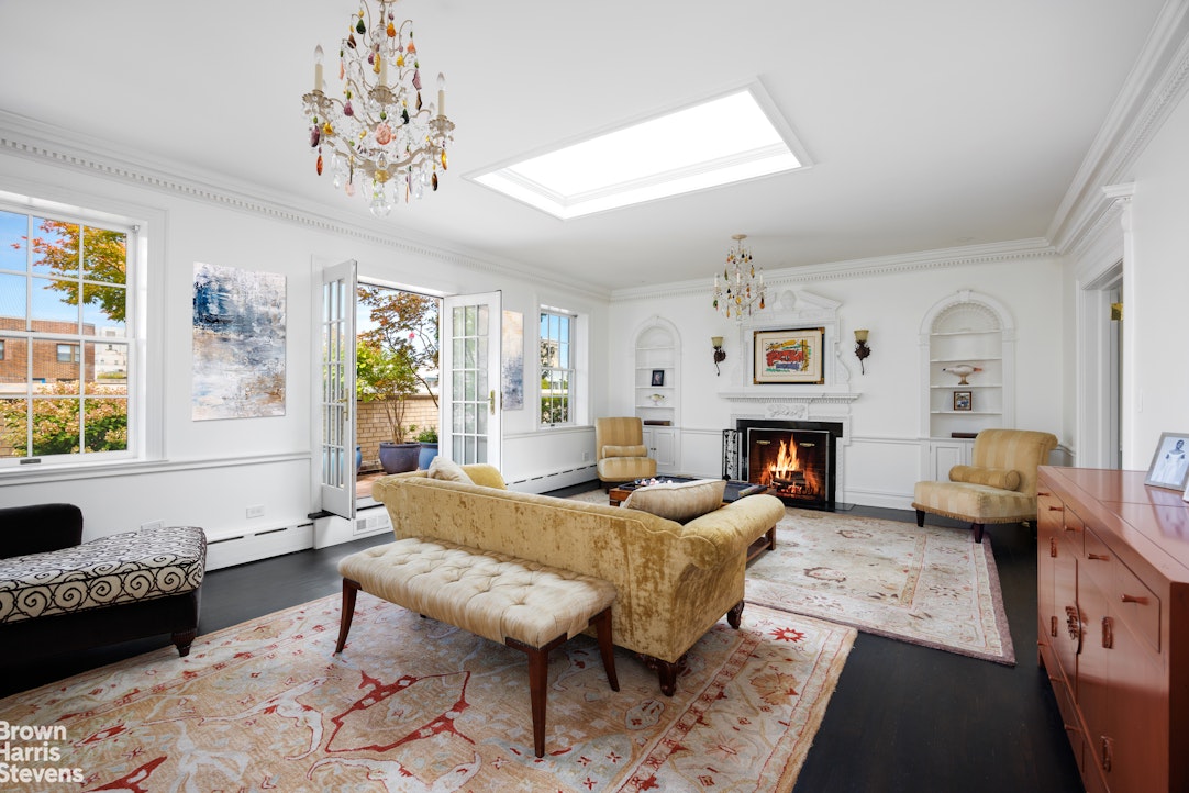 a living room with furniture a chandelier and a fireplace