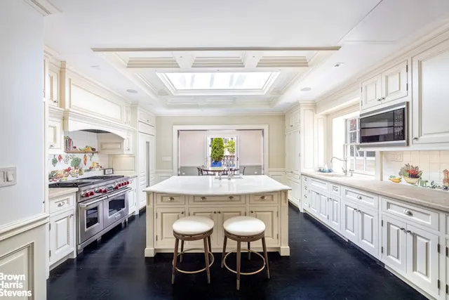 a kitchen with kitchen island granite countertop a sink a stove dining table and chairs