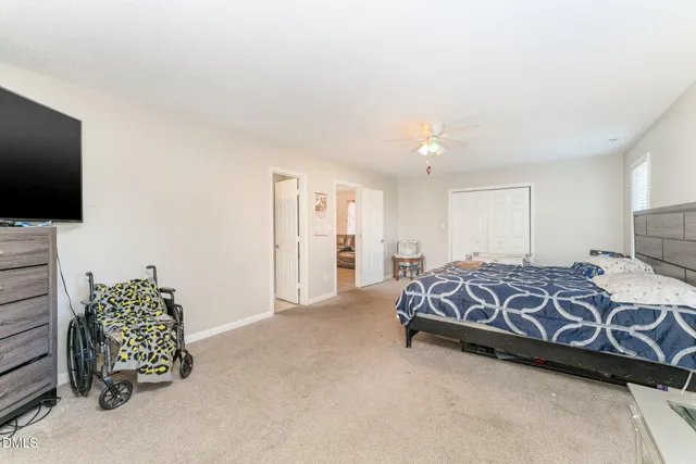 a spacious bedroom with a bed and a flat screen tv