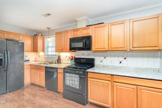 a kitchen with granite countertop a stove top oven sink and cabinets