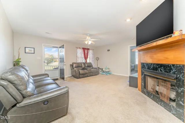 a living room with furniture a fireplace and a flat screen tv