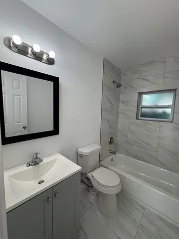 a bathroom with a toilet sink and mirror