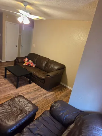 a living room with furniture and wooden floor