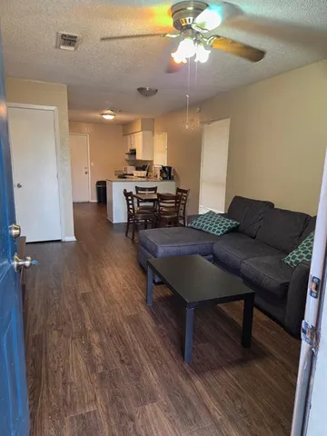 a living room with furniture and a wooden floor
