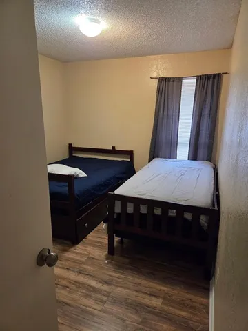 a room with a bed and wooden floor