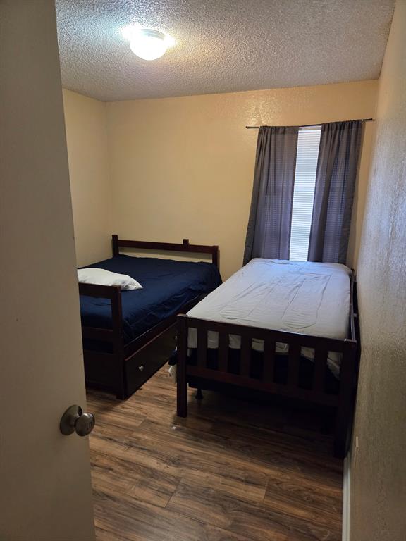 744 Sycamore Street, Unit 74 Paris, TX 75460 - Photo 7 of 10 a room with a bed and wooden floor