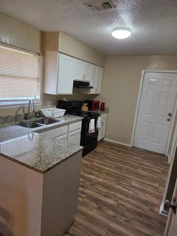 a kitchen with stainless steel appliances granite countertop a sink stove and cabinets