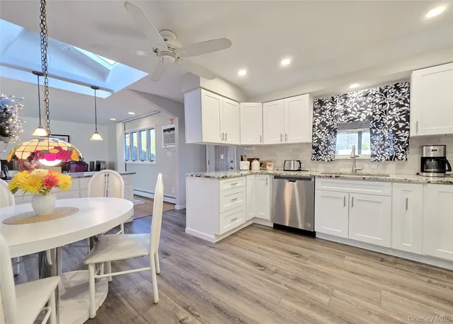 a kitchen with granite countertop white cabinets and white appliances
