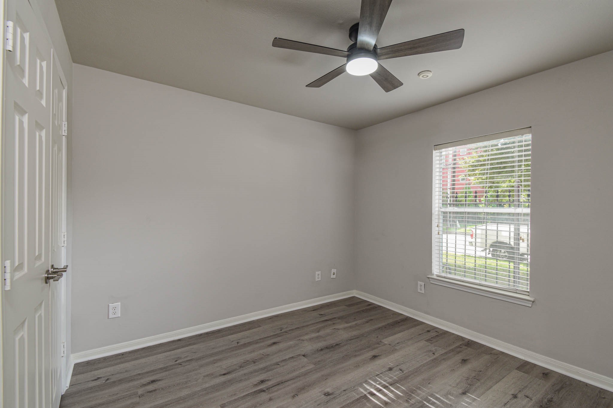 1729 Tuam Street Houston, TX 77004 - Photo 15 of 23 an empty room with wooden floor ceiling fan and windows