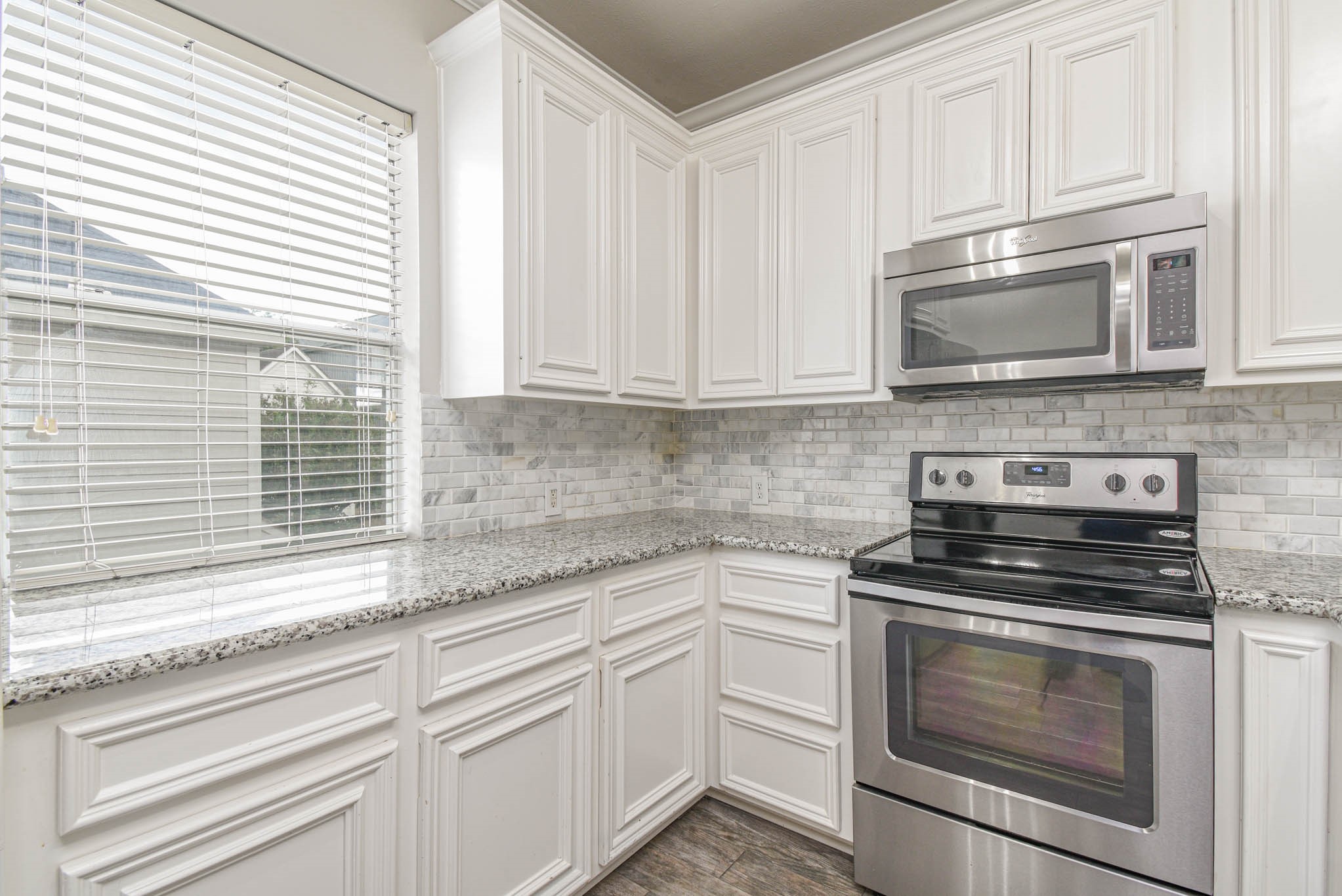 1729 Tuam Street Houston, TX 77004 - Photo 8 of 23 a kitchen with granite countertop white cabinets appliances and a window