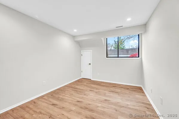an empty room with wooden floor and window