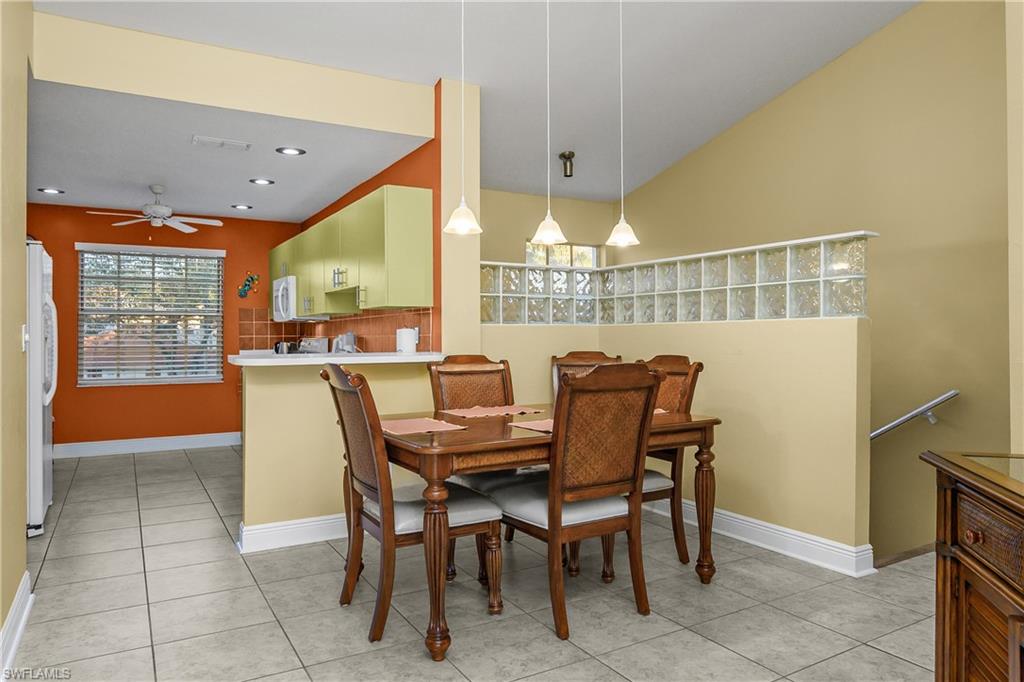541 Windsor Square, Unit 202 Naples, FL 34104 - Photo 11 of 36 a dining room with furniture and a floor to ceiling window