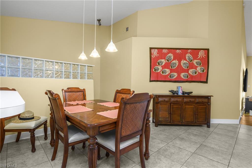 541 Windsor Square, Unit 202 Naples, FL 34104 - Photo 12 of 36 a view of a dining room with furniture window and wooden floor