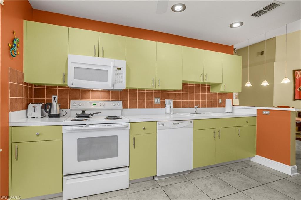 541 Windsor Square, Unit 202 Naples, FL 34104 - Photo 15 of 36 a kitchen with sink cabinets and stove