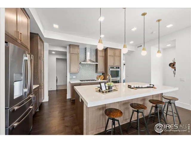 a kitchen with granite countertop a table chairs stainless steel appliances and cabinets