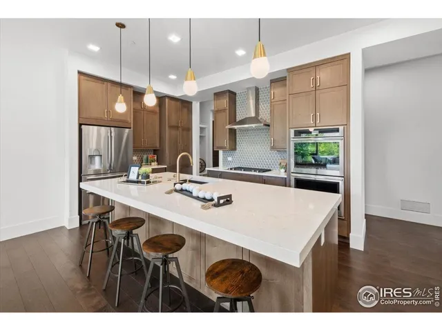 a kitchen with kitchen island a stove a table and chairs