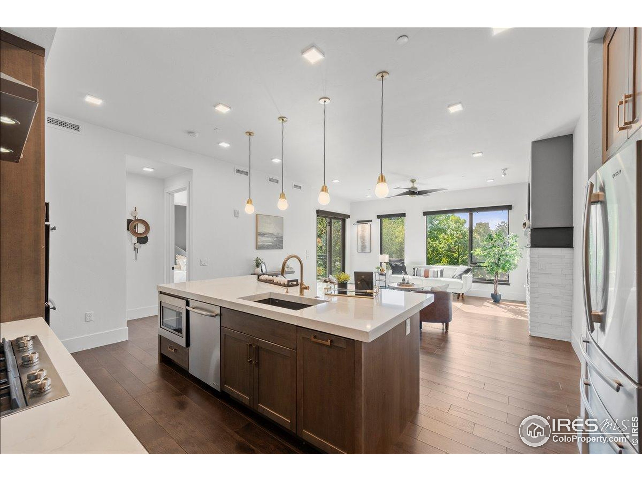 302 North Meldrum Street, Unit 313 Fort Collins, CO 80521 - Photo 13 of 36 a open kitchen with stainless steel appliances granite countertop a sink a stove a refrigerator and a dining table with wooden floor