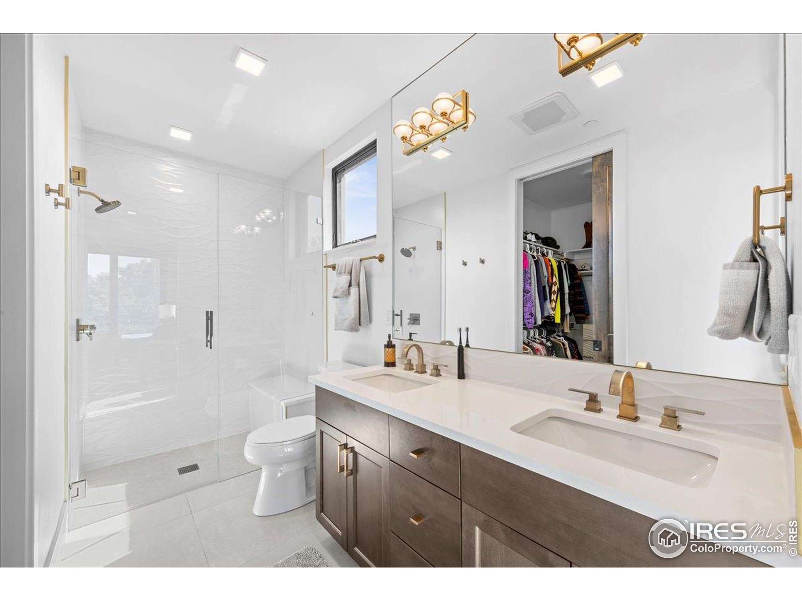 302 North Meldrum Street, Unit 313 Fort Collins, CO 80521 - Photo 19 of 36 a bathroom with a sink a toilet a large mirror and shower