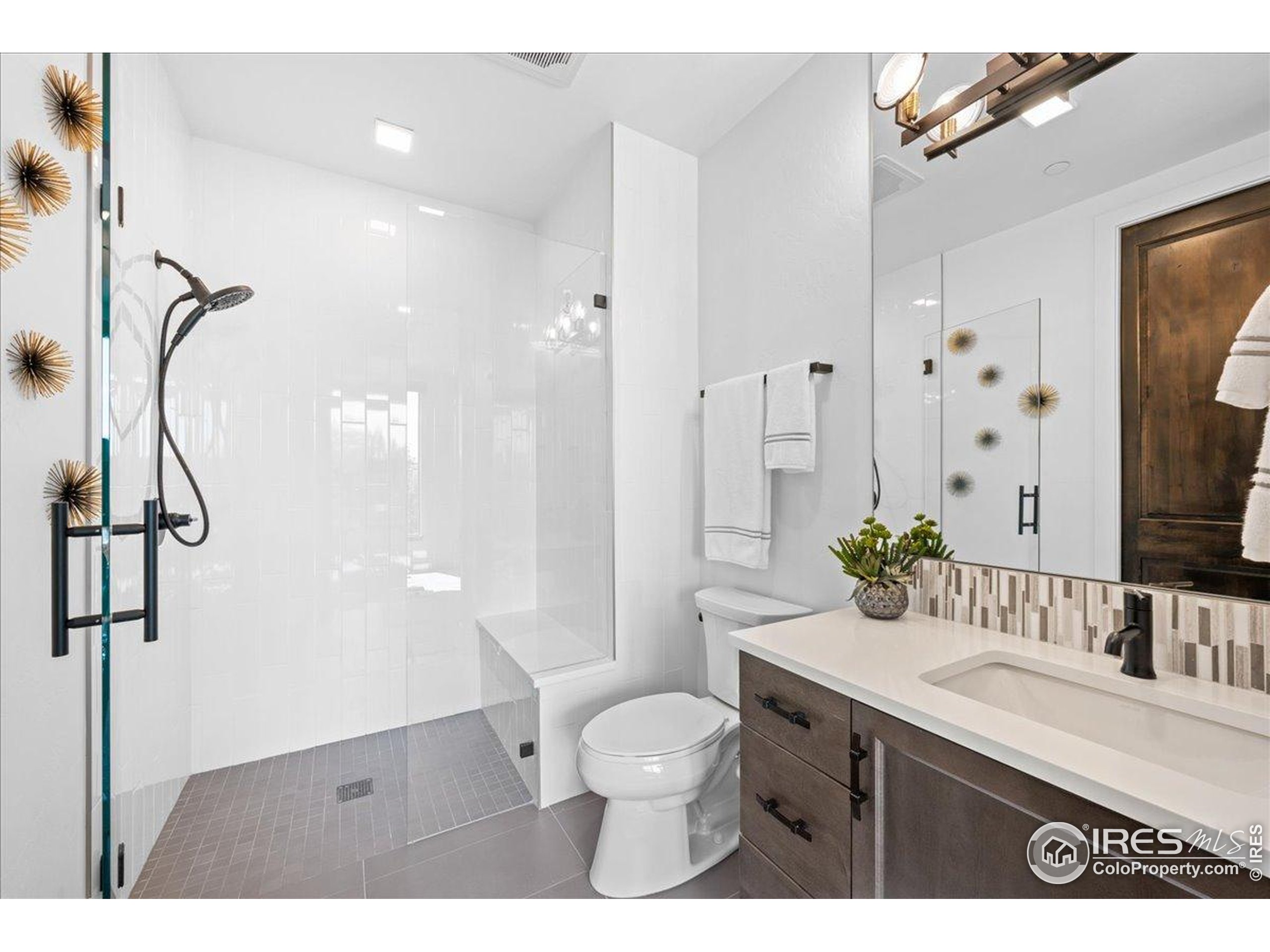 302 North Meldrum Street, Unit 313 Fort Collins, CO 80521 - Photo 22 of 36 a bathroom with a granite countertop sink toilet a mirror and shower