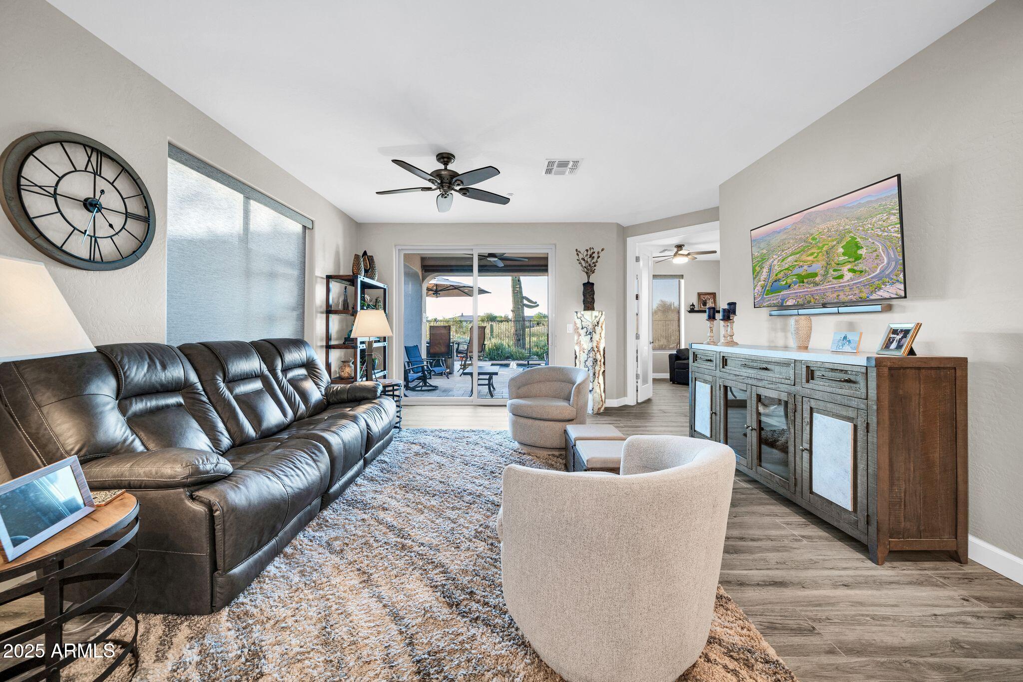 41822 North Crooked Stick Road Anthem, AZ 85086 - Photo 14 of 90 a living room with furniture a clock on wall and a table