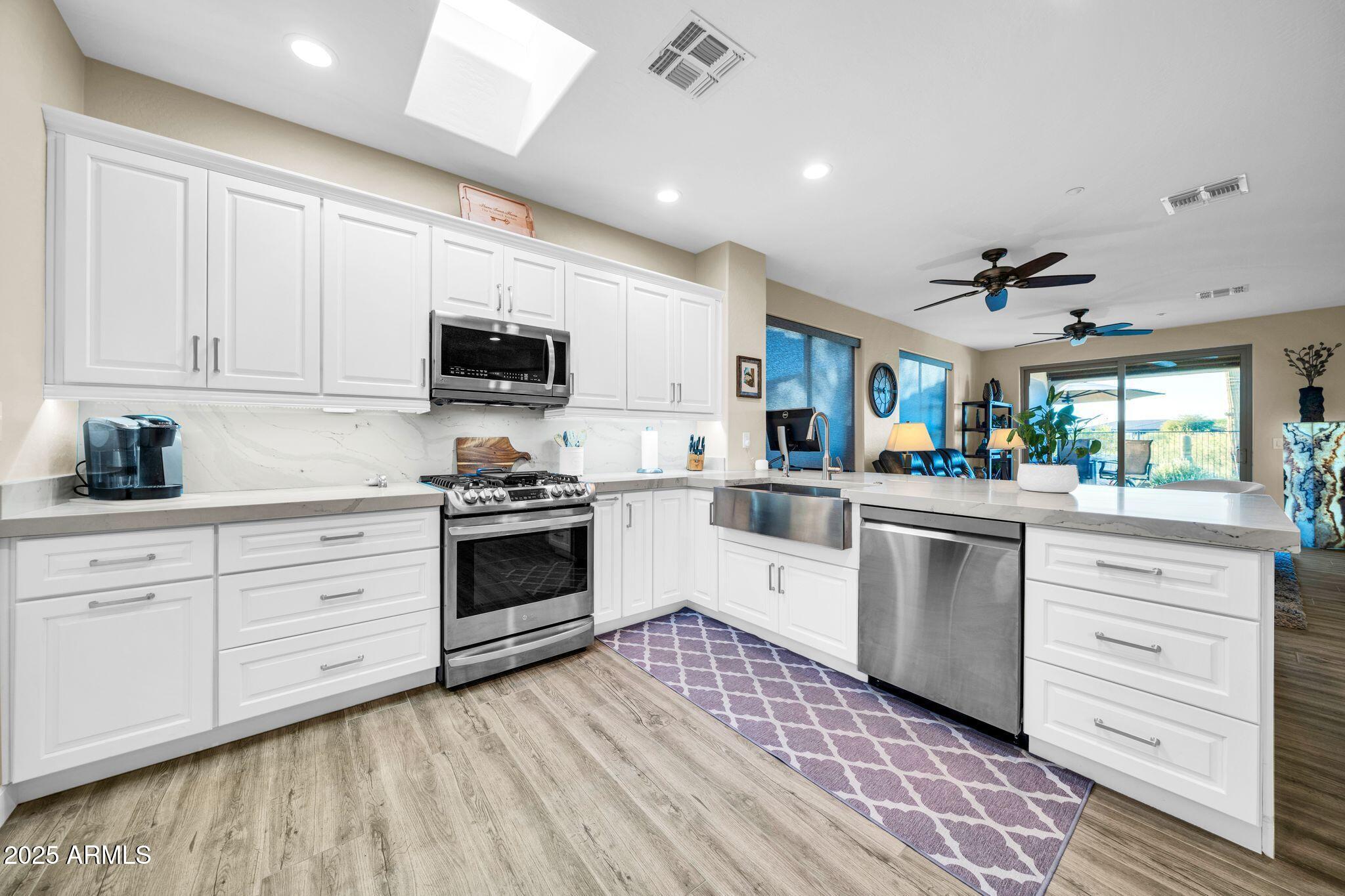 41822 North Crooked Stick Road Anthem, AZ 85086 - Photo 18 of 90 a kitchen with granite countertop white cabinets and white appliances