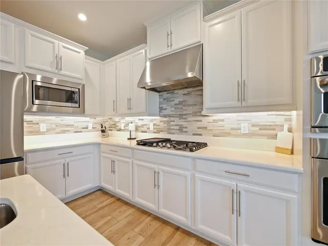 a kitchen with stainless steel appliances a refrigerator sink cabinets and microwave