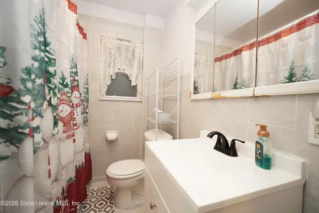 a bathroom with a sink a toilet and shower curtain