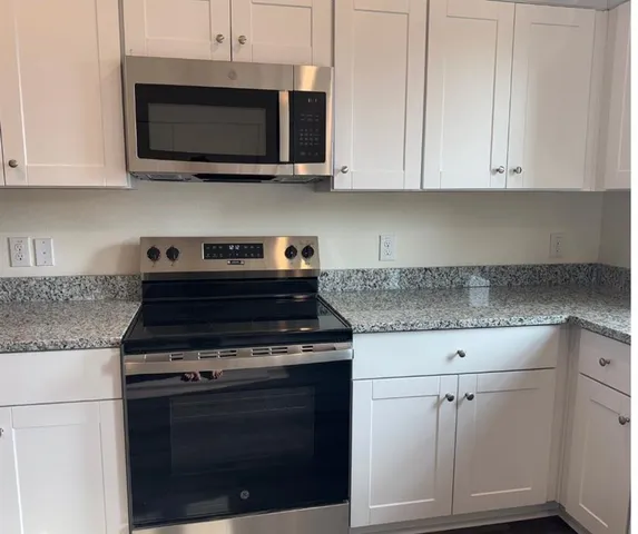 a kitchen with stainless steel appliances granite countertop a stove microwave and oven