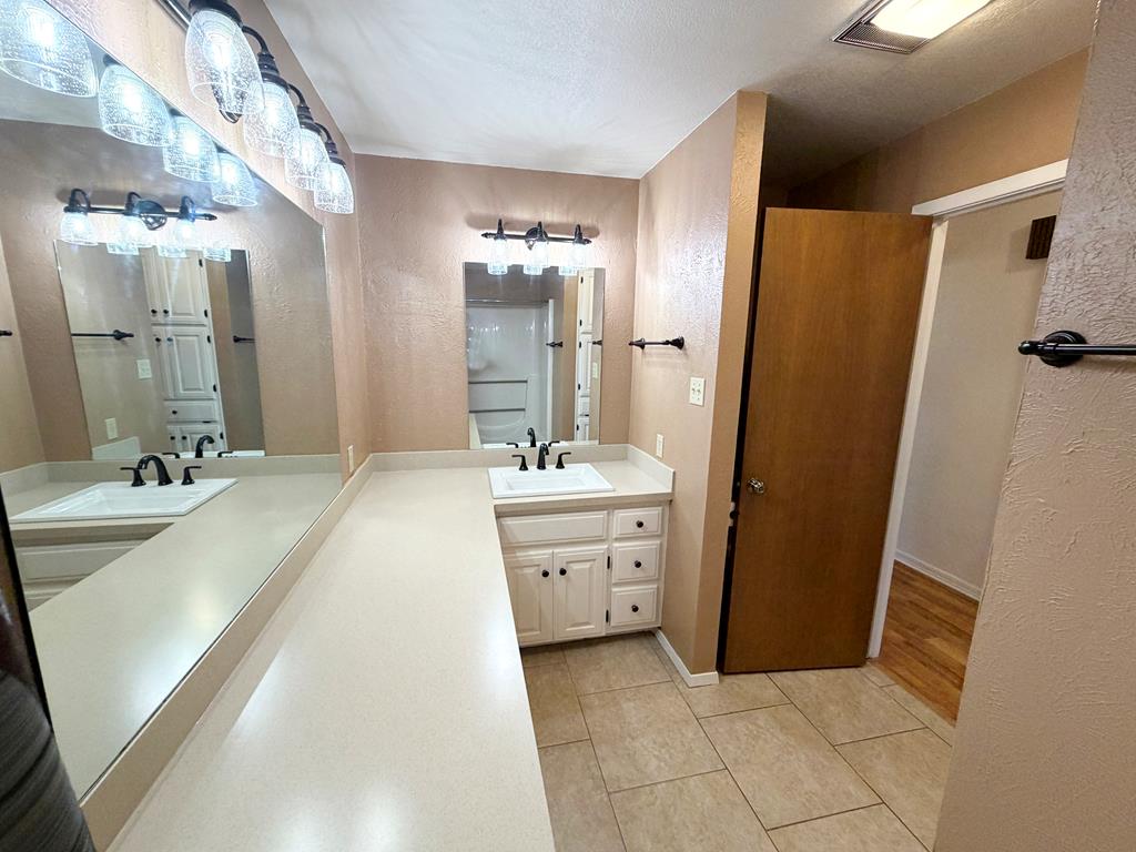 707 Rimrock Road Kerrville, TX 78028 - Photo 37 of 55 a bathroom with a double vanity sink a mirror a bathtub and shower