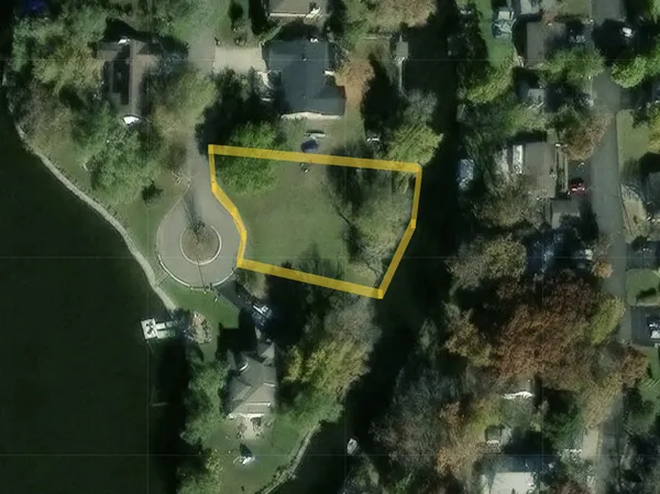 an aerial view of a residential houses with outdoor space and trees