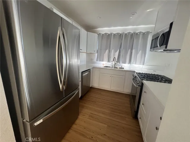 a kitchen with stainless steel appliances granite countertop a refrigerator and a sink