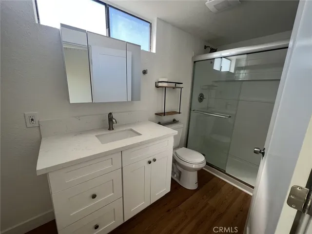 a bathroom with a sink a toilet and shower