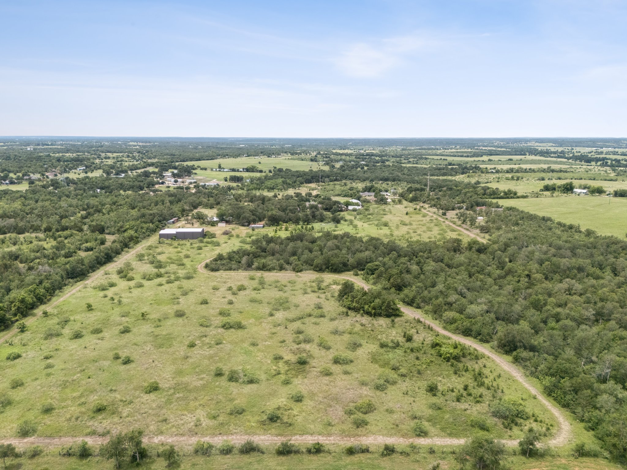 406 Monkey Road Elgin, TX 78621 - Photo 1 of 39 Expansive rural landscape featuring a mix of open fields and densely wooded areas