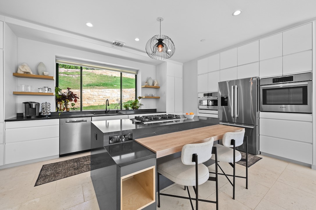 405 Barrett Lane Austin, TX 78733 - Photo 30 of 37 a kitchen with stainless steel appliances granite countertop a stove a refrigerator a oven a sink with a dining table and chairs