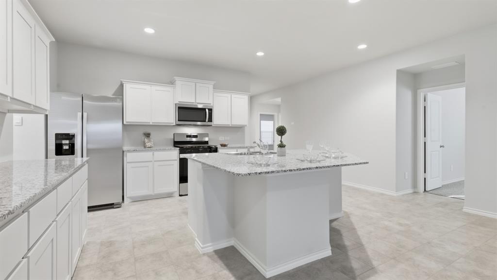 169 MLM Parkway Bridgeport, TX 76426 - Photo 19 of 21 a kitchen with white cabinets and stainless steel appliances