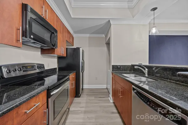 a kitchen with stainless steel appliances granite countertop a stove top oven a sink and dishwasher