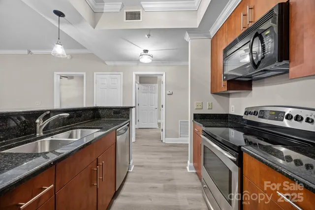 a kitchen with stainless steel appliances granite countertop a sink stove oven and cabinets