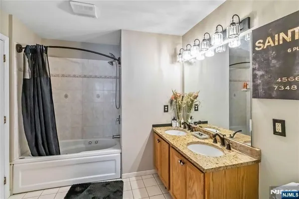 a bathroom with a tub sink and mirror