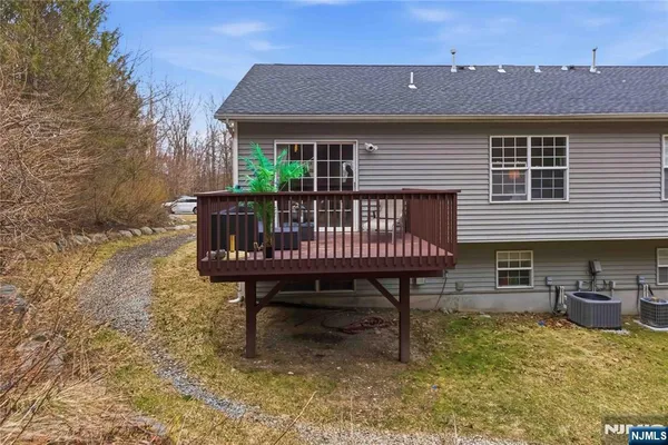 a view of a house with a wooden deck and furniture
