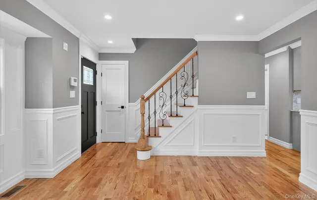a view of entryway and hall with wooden floor