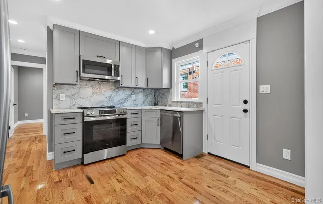 a kitchen with stainless steel appliances a stove a sink and white cabinets