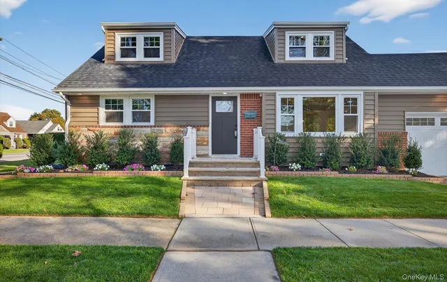 a front view of a house with garden and porch