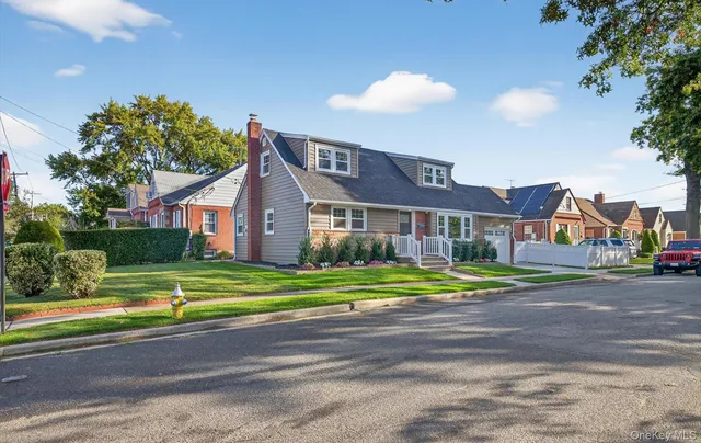 a front view of a house with a yard and trees