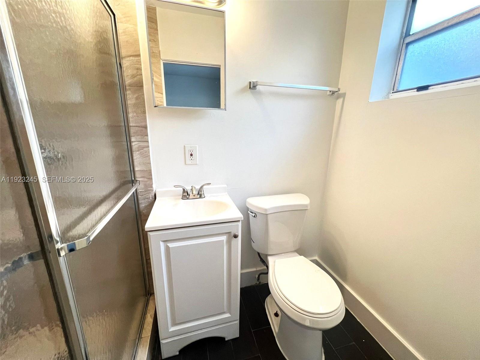 1040 Northwest 3rd Avenue, Unit 7 Miami, FL 33136 - Photo 15 of 15 a white toilet sitting next to a small sink