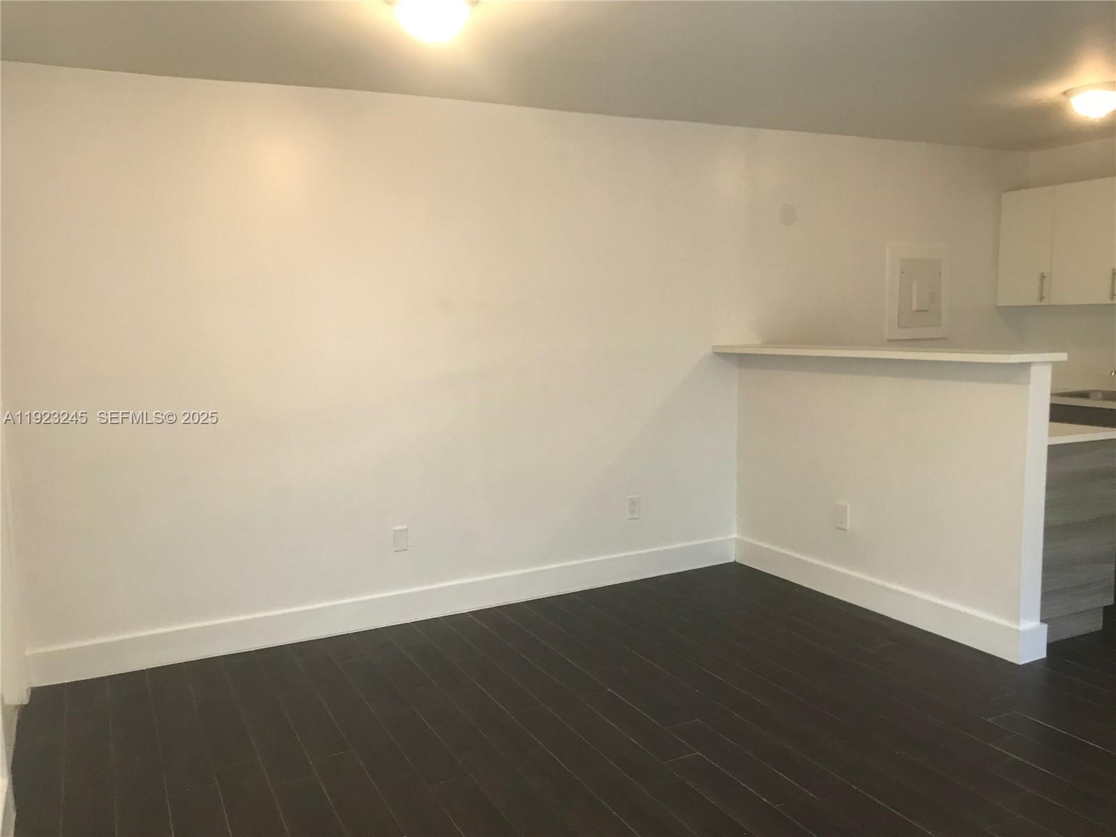 1040 Northwest 3rd Avenue, Unit 7 Miami, FL 33136 - Photo 4 of 15 an empty room with wooden floor
