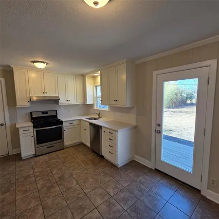 a kitchen with a sink stove and cabinets