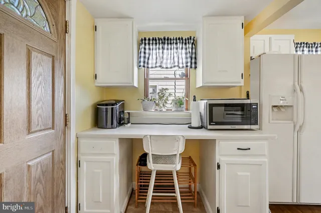 a view of a kitchen with fridge and wooden floor