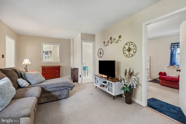 a living room with furniture a flat screen tv and a window